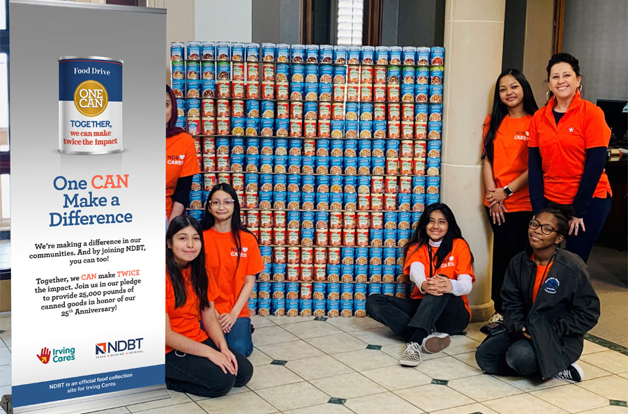 Irving students with Michelle Mercado in front of heart wall made of cans