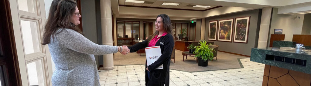 NDBT banker shaking hands with customer in Frisco banking center lobby