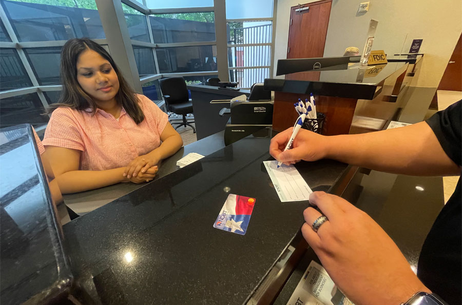 Bank teller at NDBT Addison Banking Center assisting commercial checking customer