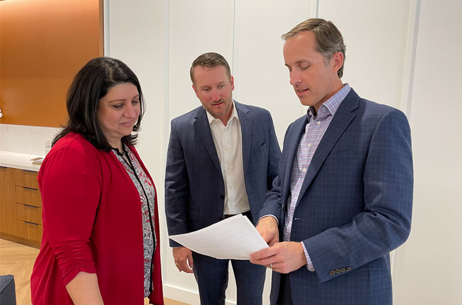 Banker reviewing documents with customers in NDBT Dallas Banking Center lobby.