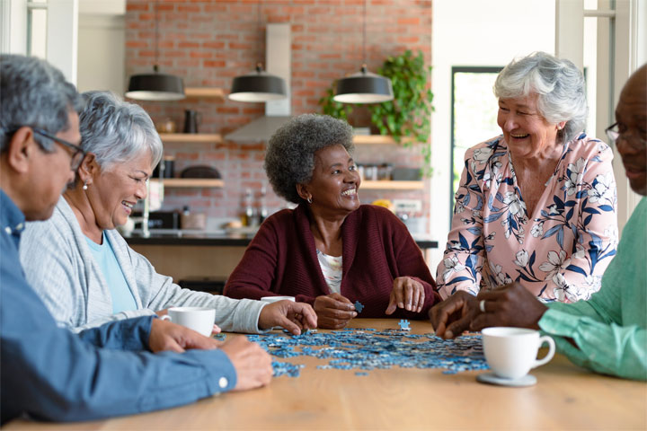 Group of elderly men and women playing dominoes at a table