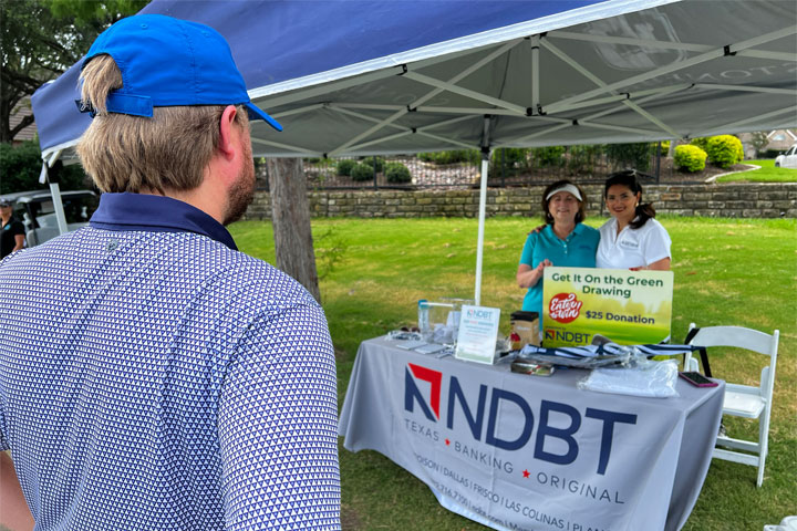 Golfer visiting NDBT table at Frisco Family Services golf tournament