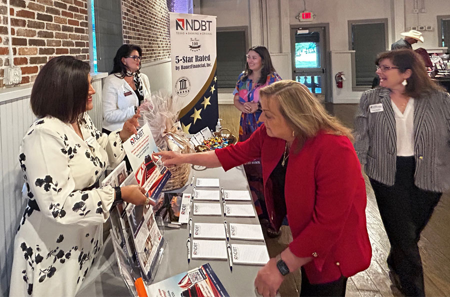 NDBT bankers sharing information with women at a vendor table