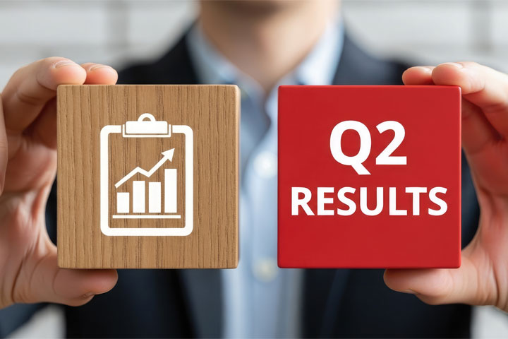 Man holding wood blocks that show a graph and the words Q2 Results